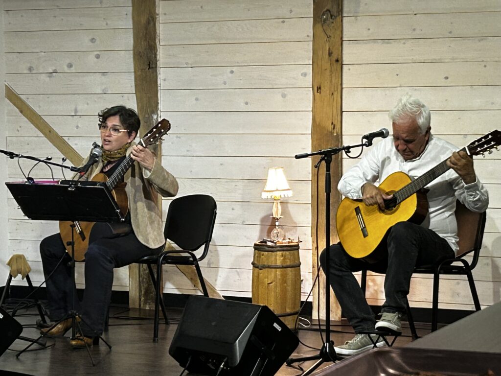 Deux musiciens jouent de la guitare sur scène lors d’un spectacle au Carrefour Coop.